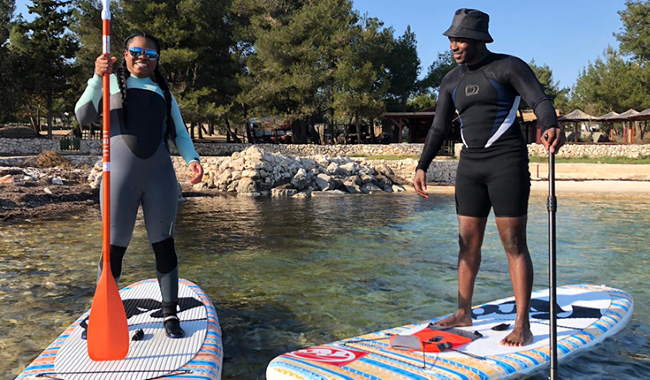 Man and female tourists starting their paddleboard tour from Vir