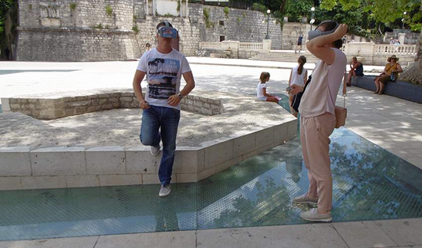 Tourists looking through VR glasses during a Virtual Reality Tour in Zadar at Petar Zoranic Square